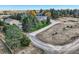 Aerial shot of the property highlighting the house, outbuilding, and long driveway surrounded by trees at 8700 Flintwood Rd, Parker, CO 80138