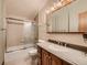 Traditional bathroom featuring a shower-tub combination with glass door and a single sink vanity at 8700 Flintwood Rd, Parker, CO 80138