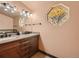 Elegant bathroom with a double sink vanity, granite countertop, and unique window design at 8700 Flintwood Rd, Parker, CO 80138