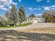 A spacious home exterior with a large driveway and mature trees at 8700 Flintwood Rd, Parker, CO 80138