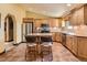 Kitchen featuring wood cabinets, an island, tile floors and stainless steel appliances at 8700 Flintwood Rd, Parker, CO 80138