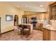 Kitchen featuring wood cabinets, stainless appliances, island with barstools, tile floor and arched doorway at 8700 Flintwood Rd, Parker, CO 80138