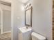 Updated bathroom featuring a modern vanity, decorative mirror, stylish lighting, and tile accents at 1731 Uinta St, Denver, CO 80220