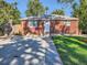 Charming single-story red brick home with a well-manicured lawn and white trim at 1731 Uinta St, Denver, CO 80220
