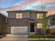 Beautiful two-story home featuring stone accents, a two-car garage, and a well-manicured lawn at 6068 Hourglass Dr, Brighton, CO 80601