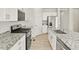 Well-equipped kitchen featuring granite counters, stainless steel appliances, white cabinets, and wood-look flooring at 6068 Hourglass Dr, Brighton, CO 80601