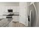 Bright kitchen features granite countertops, stainless steel appliances and white cabinets at 6068 Hourglass Dr, Brighton, CO 80601
