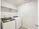 Well-lit laundry room featuring modern Whirlpool washer and dryer set and built-in shelving at 6068 Hourglass Dr, Brighton, CO 80601