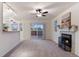 Bright living room featuring a fireplace, ceiling fan and sliding door access to the deck at 12734 Eudora Dr, Thornton, CO 80241