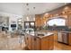 Open-concept kitchen with an island and stainless steel appliances leads to a spacious living room with fireplace at 18496 Pixie Park Rd, Monument, CO 80132