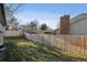 Backyard view shows a wood fence, grass, and brickwork at 13215 Peacock Dr, Lone Tree, CO 80124