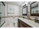 Clean bathroom with double sinks, marble tiling, modern fixtures, and a framed mirror at 13215 Peacock Dr, Lone Tree, CO 80124