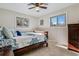 Comfortable bedroom with dual windows, a wooden bed frame and matching dresser at 13215 Peacock Dr, Lone Tree, CO 80124