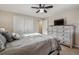 Bright bedroom with a dresser featuring a TV and a large closet in the corner at 13215 Peacock Dr, Lone Tree, CO 80124