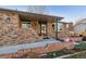 Close up of the brick home's entrance with a covered porch and bay window at 13215 Peacock Dr, Lone Tree, CO 80124