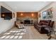 Cozy living room featuring a stone fireplace, wood accent wall, and comfortable seating with natural light at 13215 Peacock Dr, Lone Tree, CO 80124