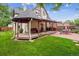 Charming backyard featuring a covered deck, brick patio, and lush green lawn, perfect for outdoor relaxation at 912 S Washington St, Denver, CO 80209