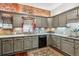 Charming kitchen featuring grey cabinets, granite countertops, stainless steel appliances, and eye-catching exposed brick wall at 912 S Washington St, Denver, CO 80209