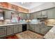 Grey cabinets, granite countertops, and stainless appliances highlight this kitchen's charm, complete with exposed brick accents at 912 S Washington St, Denver, CO 80209
