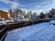 Snow covered backyard with a wooden fence and large trees creates a winter wonderland at 30819 Hilltop Dr, Evergreen, CO 80439