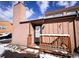 Exterior of the house with a wooden porch and a snowy yard on a sunny day at 30819 Hilltop Dr, Evergreen, CO 80439