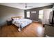 Light-filled main bedroom with natural light, ceiling fan, hardwood floors and neutral decor at 30819 Hilltop Dr, Evergreen, CO 80439