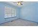 Bright, simply staged bedroom with neutral carpet, painted blue, and a window providing natural light at 8867 Yukon St # 49, Broomfield, CO 80021