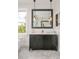 Bright bathroom with a dark vanity, herringbone tile floor, modern pendant lighting, and an adjacent soaking tub at 5397 Lenox Ct, Castle Rock, CO 80104
