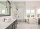 Bright bathroom with a large glass shower, soaking tub, and vanity with modern fixtures and gray herringbone floor at 5397 Lenox Ct, Castle Rock, CO 80104