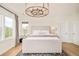 Bright bedroom with a tufted headboard, gray rug, and modern chandelier, creating a cozy and inviting space at 5397 Lenox Ct, Castle Rock, CO 80104