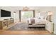 Bright, spacious bedroom featuring hardwood floors, tufted headboard, modern lighting, and large windows at 5397 Lenox Ct, Castle Rock, CO 80104