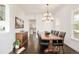 Dining room with dark hardwood floors, a large wood table, black leather chairs, and a modern chandelier at 5397 Lenox Ct, Castle Rock, CO 80104