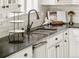 Detailed view of a kitchen sink with a dark countertop and white cabinets at 5397 Lenox Ct, Castle Rock, CO 80104