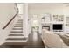 Cozy living room showcasing a staircase, fireplace, built-in shelving, and comfortable seating area with hardwood floors at 5397 Lenox Ct, Castle Rock, CO 80104
