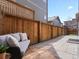 Private backyard patio area with outdoor seating surrounded by a wooden privacy fence at 10000 E 59Th Dr, Denver, CO 80238