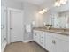 Bright bathroom featuring double vanity with stone counters, white cabinets, and a glass-enclosed shower at 10000 E 59Th Dr, Denver, CO 80238