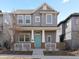 Charming two-story home with a welcoming front porch and a bright blue front door at 10000 E 59Th Dr, Denver, CO 80238