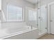 Luxurious main bathroom with soaking tub and glass-enclosed walk-in shower at 10000 E 59Th Dr, Denver, CO 80238