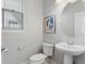 Charming powder room features a pedestal sink, framed mirror, and natural light at 10000 E 59Th Dr, Denver, CO 80238