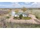 Expansive aerial view of a white home with outbuildings on a large rural lot at 17445 County Road 6, Brighton, CO 80603