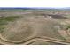 Aerial view of land with the home and outbuildings nestled within the landscape at 17445 County Road 6, Brighton, CO 80603