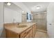 Bathroom featuring a double sink vanity with a large mirror and glass enclosed shower at 17445 County Road 6, Brighton, CO 80603