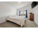 Bright bedroom with large bed, a dresser and a window with blue curtains at 17445 County Road 6, Brighton, CO 80603