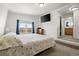 Bright bedroom with large bed, dresser, mounted television and en suite restroom at 17445 County Road 6, Brighton, CO 80603