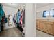 Walk-in closet with hanging clothes and shelves next to the en suite restroom at 17445 County Road 6, Brighton, CO 80603