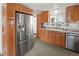 Well-lit kitchen with stainless steel refrigerator and ample wood cabinetry at 17445 County Road 6, Brighton, CO 80603
