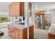 Kitchen with stainless steel refrigerator and wood cabinetry near restroom at 17445 County Road 6, Brighton, CO 80603