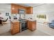 Kitchen with stainless steel oven and wood cabinets adjacent to living area at 17445 County Road 6, Brighton, CO 80603