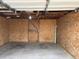 Interior view of outbuilding showing plywood walls, concrete floor, and door at 17445 County Road 6, Brighton, CO 80603