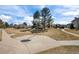 Outdoor basketball court with a hoop, surrounded by grass and mature trees, perfect for recreational activities at 3351 S Field St # 104, Lakewood, CO 80227